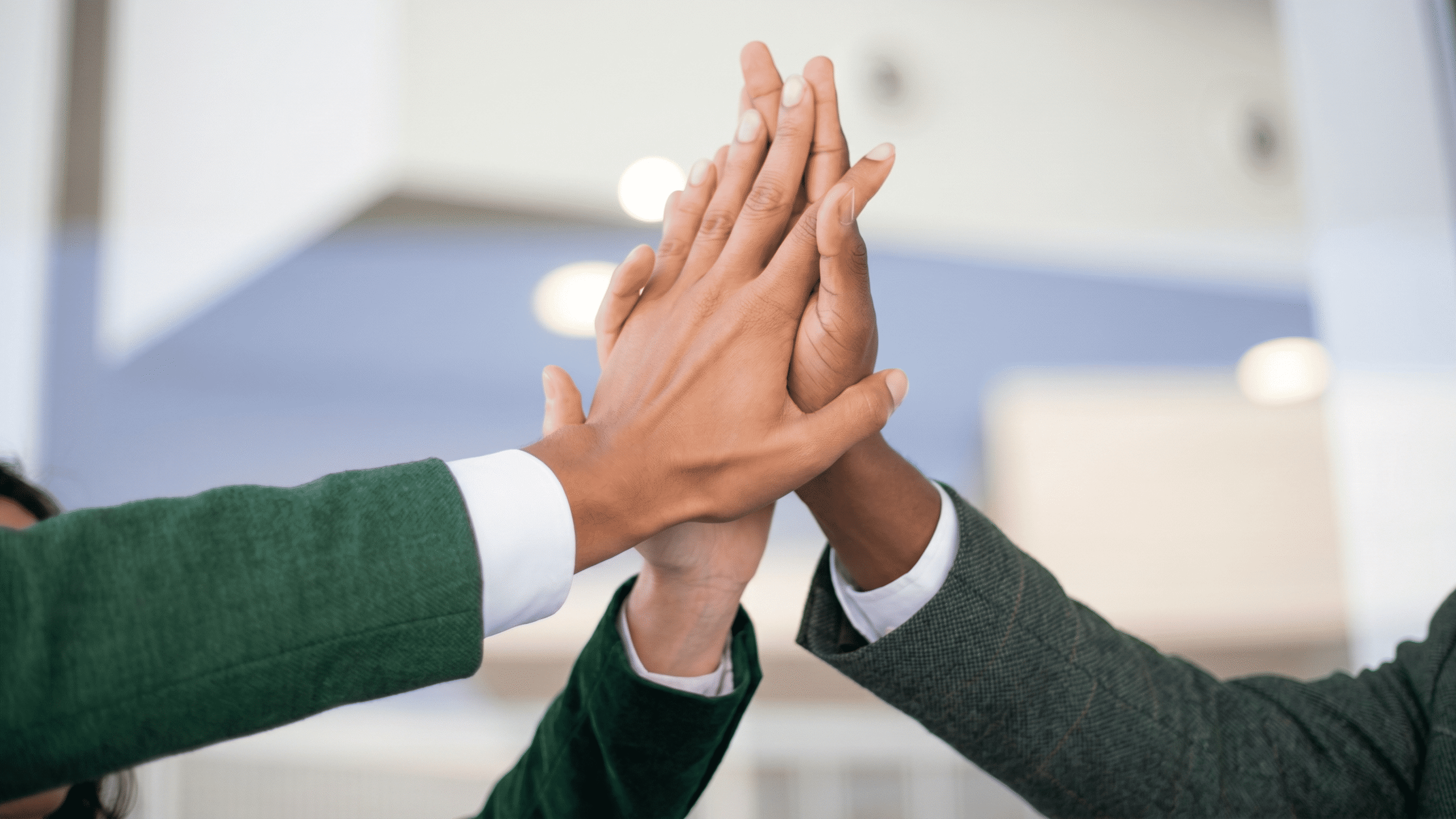 Team members giving a high five, representing collaboration and shared success in business