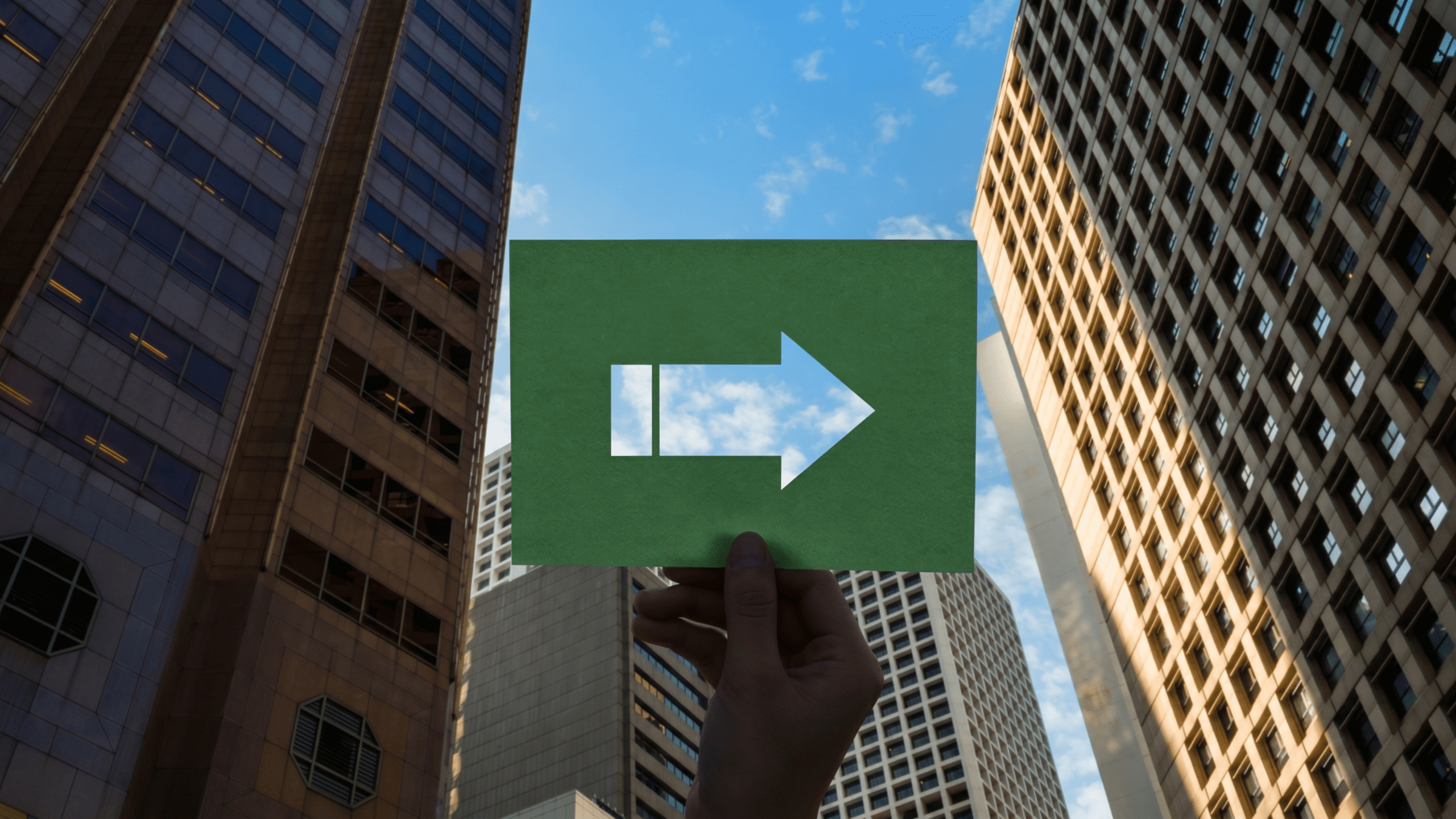  Hand holding arrow symbol pointing forward against Cebu business district, representing growth and future direction