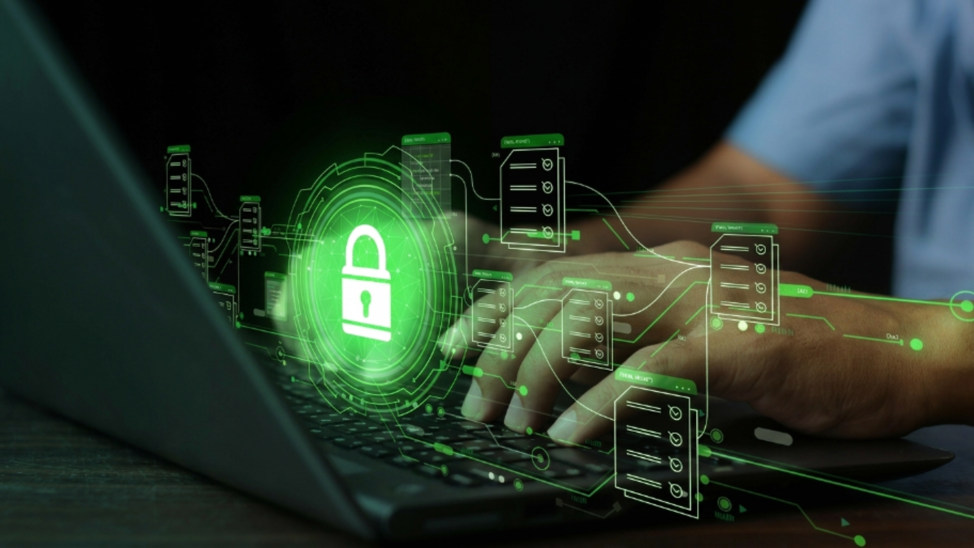 Person using a laptop with a digital security lock overlay, representing cybersecurity, data protection, and secure digital operations.
